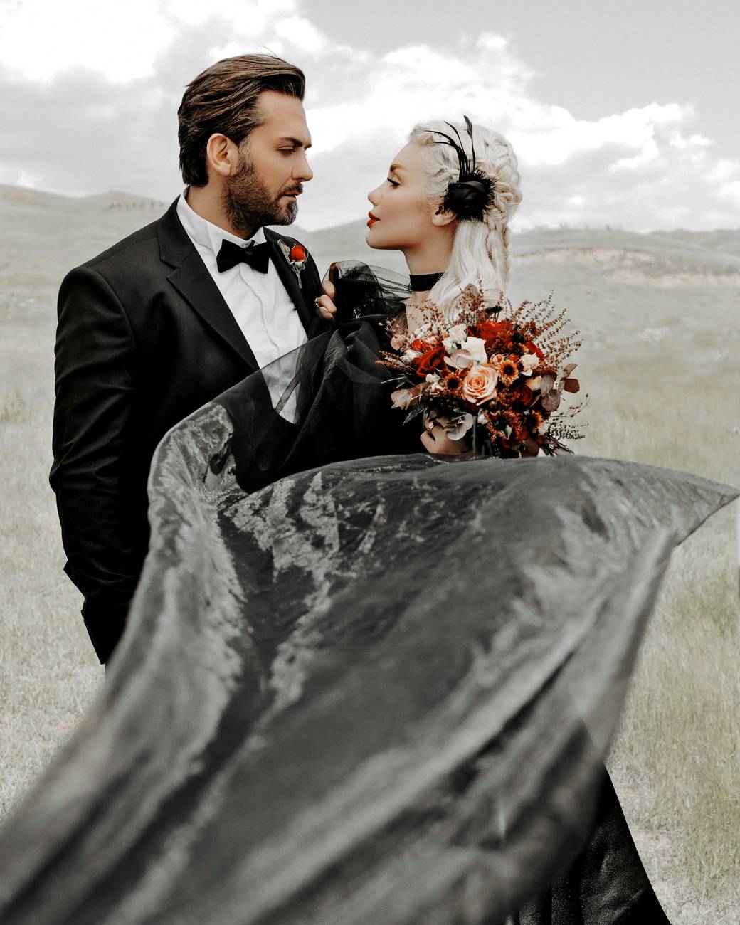 A couple in wedding outfits riding in a car